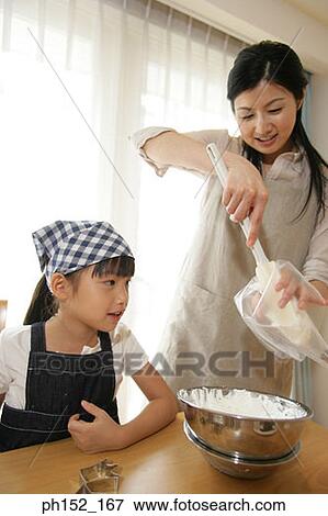 Mid adult woman and her daughter preparing batter View Large Photo Image Stock Photo - Mid adult woman and her daughter preparing batter. Fotosearch