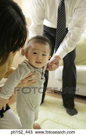 Portrait of a baby boy standing with the help of his parents View Large Photo Image Stock Image - Portrait of a baby boy standing with the help of his parents. Fotosearch