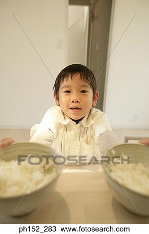 Portrait of a boy holding two bowls of food View Large Photo Image Stock Image - Portrait of a boy holding two bowls of food. Fotosearch