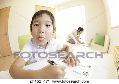 Portrait of a boy sticking his tongue out with his sister using a laptop in the background View Large Photo Image Stock Image - Portrait of a boy sticking his tongue out with his sister using a laptop in the background. Fotosearch