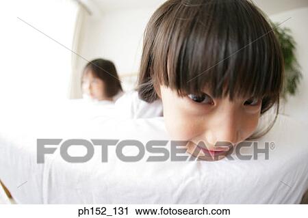 Portrait of a girl lying on the bed with her sister in the background View Large Photo Image Stock Image - Portrait of a girl lying on the bed with her sister in the background. Fotosearch