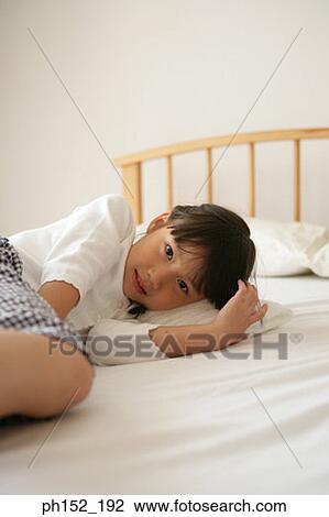 Portrait of a girl lying on the bed View Large Photo Image Stock Image - Portrait of a girl lying on the bed. Fotosearch