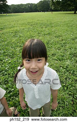 Portrait of a girl standing in a park View Large Photo Image Stock Photo - Portrait of a girl standing in a park. Fotosearch
