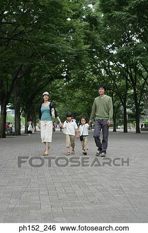 Portrait of a mid adult couple walking with their two daughters View Large Photo Image Stock Photograph - Portrait of a mid adult couple walking with their two daughters. Fotosearch