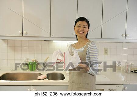 Portrait of a mid adult woman cleaning a glass with a duster View Large Photo Image Stock Photograph - Portrait of a mid adult woman cleaning a glass with a duster. Fotosearch