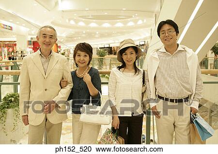 Portrait of a senior couple and a mid adult couple standing in a shopping mall View Large Photo Image Stock Image - Portrait of a senior couple and a mid adult couple standing in a shopping mall. Fotosearch