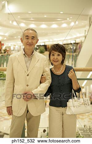 Stock Image - Portrait of a senior couple smiling in a shopping mall. Fotosearch