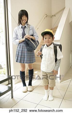 Stock Image - Portrait of a teenage girl and her brother smiling. Fotosearch