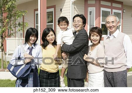 Stock Photo - Portrait of a three generation family standing together and smiling. Fotosearch
