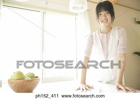 Portrait of a young woman cleaning a table and smiling View Large Photo Image Stock Image - Portrait of a young woman cleaning a table and smiling. Fotosearch