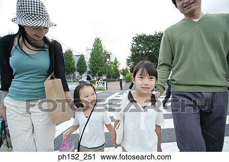 Portrait of two girls crossing the road with their parents View Large Photo Image Stock Image - Portrait of two girls crossing the road with their parents. Fotosearch