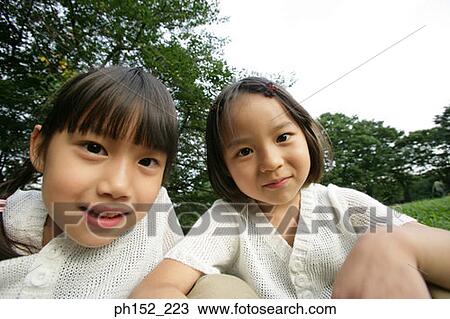 Portrait of two girls in a park View Large Photo Image Stock Image - Portrait of two girls in a park. Fotosearch
