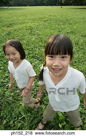 Portrait of two girls in a park View Large Photo Image Stock Photo - Portrait of two girls in a park. Fotosearch