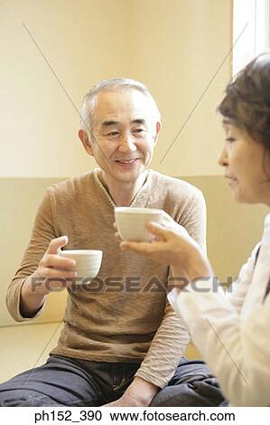 Stock Image - Senior couple holding cups. Fotosearch