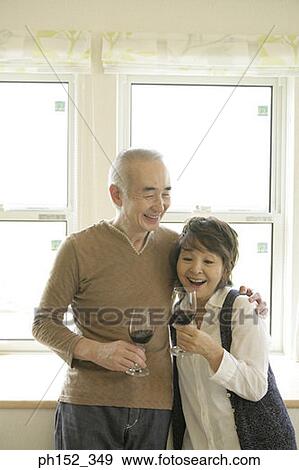 Senior couple holding glasses of red wine and smiling View Large Photo Image Stock Photo - Senior couple holding glasses of red wine and smiling. Fotosearch