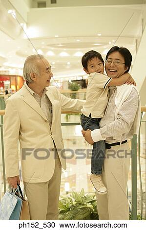 Stock Image - Senior man standing beside his son and his grandson. Fotosearch