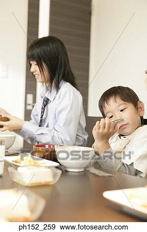 Stock Photo - Side profile of a girl and her brother at the dining table. Fotosearch
