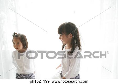 Side profile of a girl standing with her sister and smiling View Large Photo Image Stock Photo - Side profile of a girl standing with her sister and smiling. Fotosearch