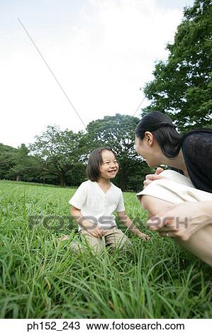 Side profile of a mid adult woman and her daughter playing in the park View Large Photo Image Stock Image - Side profile of a mid adult woman and her daughter playing in the park. Fotosearch