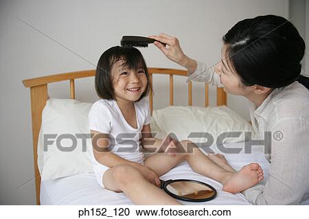 Side profile of a mid adult woman brushing her daughter's hair View Large Photo Image Stock Image - Side profile of a mid adult woman brushing her daughter's hair. Fotosearch