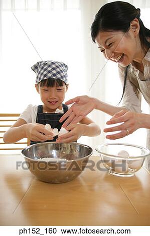 Side profile of a mid adult woman helping her daughter break an egg into a bowl View Large Photo Image Stock Image - Side profile of a mid adult woman helping her daughter break an egg into a bowl. Fotosearch