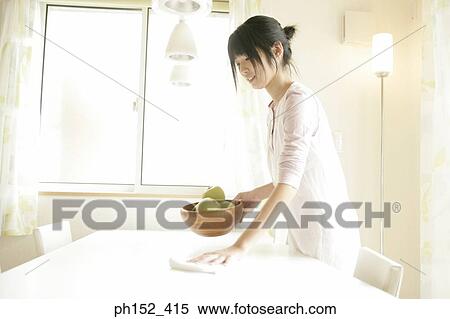 Side profile of a young woman cleaning the table and holding a bowl of apples View Large Photo Image Stock Photography - Side profile of a young woman cleaning the table and holding a bowl of apples. Fotosearch