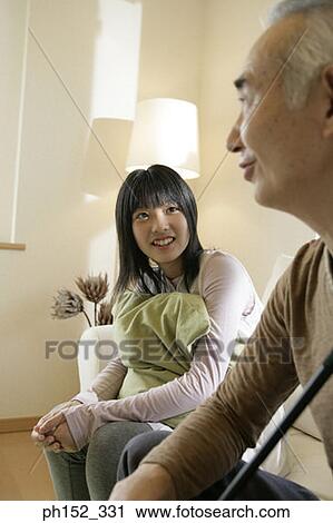 Teenage girl and her grandfather sitting on a couch and smiling View Large Photo Image Stock Image - Teenage girl and her grandfather sitting on a couch and smiling. Fotosearch