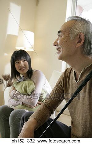 Teenage girl and her grandfather sitting on a couch and smiling View Large Photo Image Stock Image - Teenage girl and her grandfather sitting on a couch and smiling. Fotosearch
