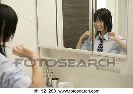 Teenage girl looking at herself in the mirror and smiling View Large Photo Image Stock Photo - Teenage girl looking at herself in the mirror and smiling. Fotosearch