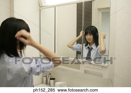 Teenage girl looking at herself in the mirror View Large Photo Image Stock Photography - Teenage girl looking at herself in the mirror. Fotosearch