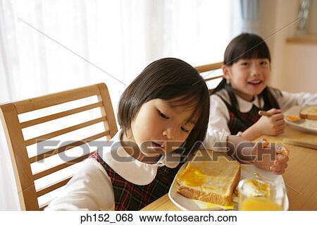 Two girls at the dining table View Large Photo Image Stock Photo - Two girls at the dining table. Fotosearch