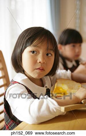 Stock Photo - Two girls at the dining table. Fotosearch