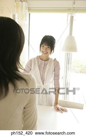 Young woman looking at her mother and smiling View Large Photo Image Stock Image - Young woman looking at her mother and smiling. Fotosearch