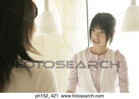 Stock Image - Young woman looking at her mother. Fotosearch