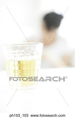 Close-up of a glass of white wine with a woman in the background View Large Photo Image Stock Image - Close-up of a glass of white wine with a woman in the background. Fotosearch