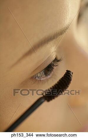 Close-up of a young woman applying mascara View Large Photo Image Picture - Close-up of a young woman applying mascara. Fotosearch