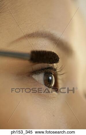 Stock Photography - Close-up of a young woman applying mascara. Fotosearch