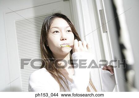 Picture - Close-up of a young woman brushing her teeth. Fotosearch