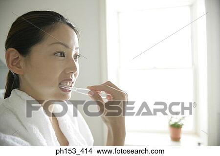 Close-up of a young woman brushing her teeth View Large Photo Image Picture - Close-up of a young woman brushing her teeth. Fotosearch