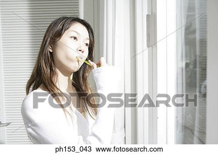 Close-up of a young woman brushing her teeth View Large Photo Image Stock Image - Close-up of a young woman brushing her teeth. Fotosearch