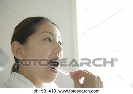 Close-up of a young woman brushing her teeth View Large Photo Image Stock Image - Close-up of a young woman brushing her teeth. Fotosearch