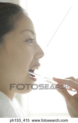 Close-up of a young woman brushing her teeth View Large Photo Image Stock Photography - Close-up of a young woman brushing her teeth. Fotosearch