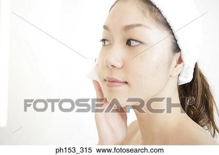 Close-up of a young woman cleaning her face with a tissue paper View Large Photo Image Stock Photography - Close-up of a young woman cleaning her face with a tissue paper. Fotosearch