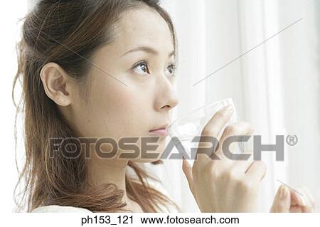 Close-up of a young woman drinking a glass of water View Large Photo Image Stock Image - Close-up of a young woman drinking a glass of water. Fotosearch