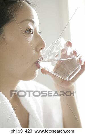 Close-up of a young woman drinking a glass of water View Large Photo Image Stock Image - Close-up of a young woman drinking a glass of water. Fotosearch