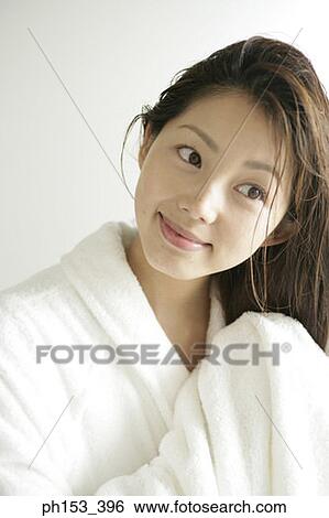 Close-up of a young woman drying her hair with a towel View Large Photo Image Stock Photograph - Close-up of a young woman drying her hair with a towel. Fotosearch