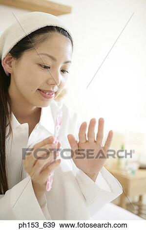 Close-up of a young woman filing her nails View Large Photo Image Stock Photo - Close-up of a young woman filing her nails. Fotosearch