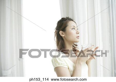 Close-up of a young woman holding a glass of water View Large Photo Image Picture - Close-up of a young woman holding a glass of water. Fotosearch