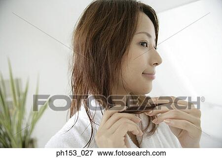 Stock Photo - Close-up of a young woman holding her hair. Fotosearch