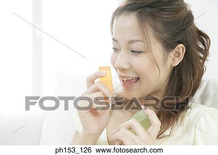 Stock Photograph - Close-up of a young woman holding two bars of soap. Fotosearch